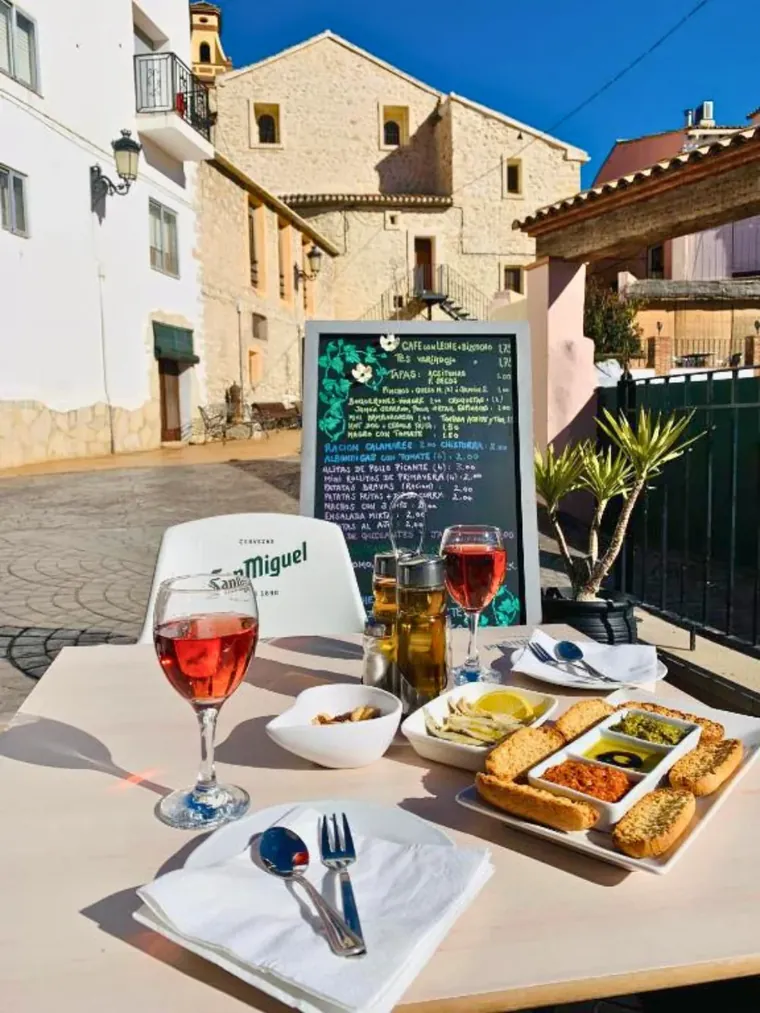 Wine and tapas on the terrace, the day's menu chalked up behind