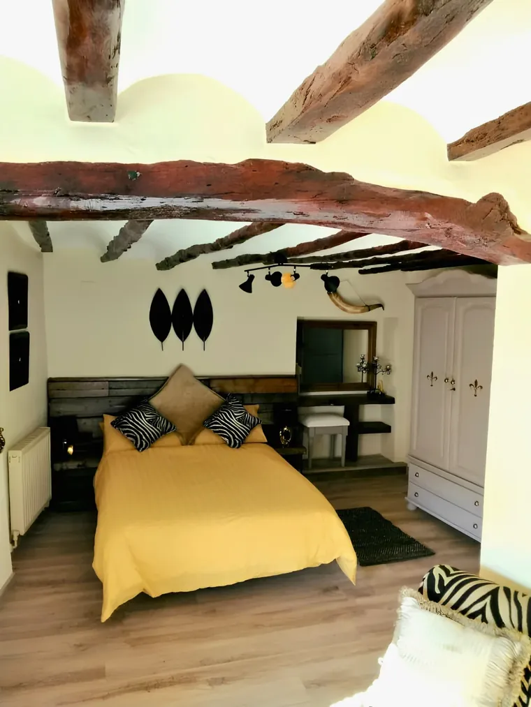 A double room at Casa Blanca: original beams, yellow bedspread and the painted wardrobe