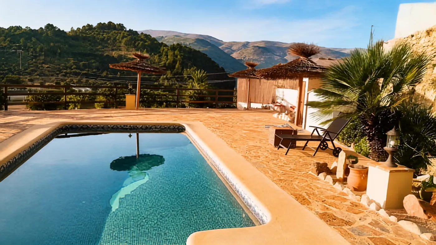The pool at Casa Blanca with straw parasols and the mountains beyond