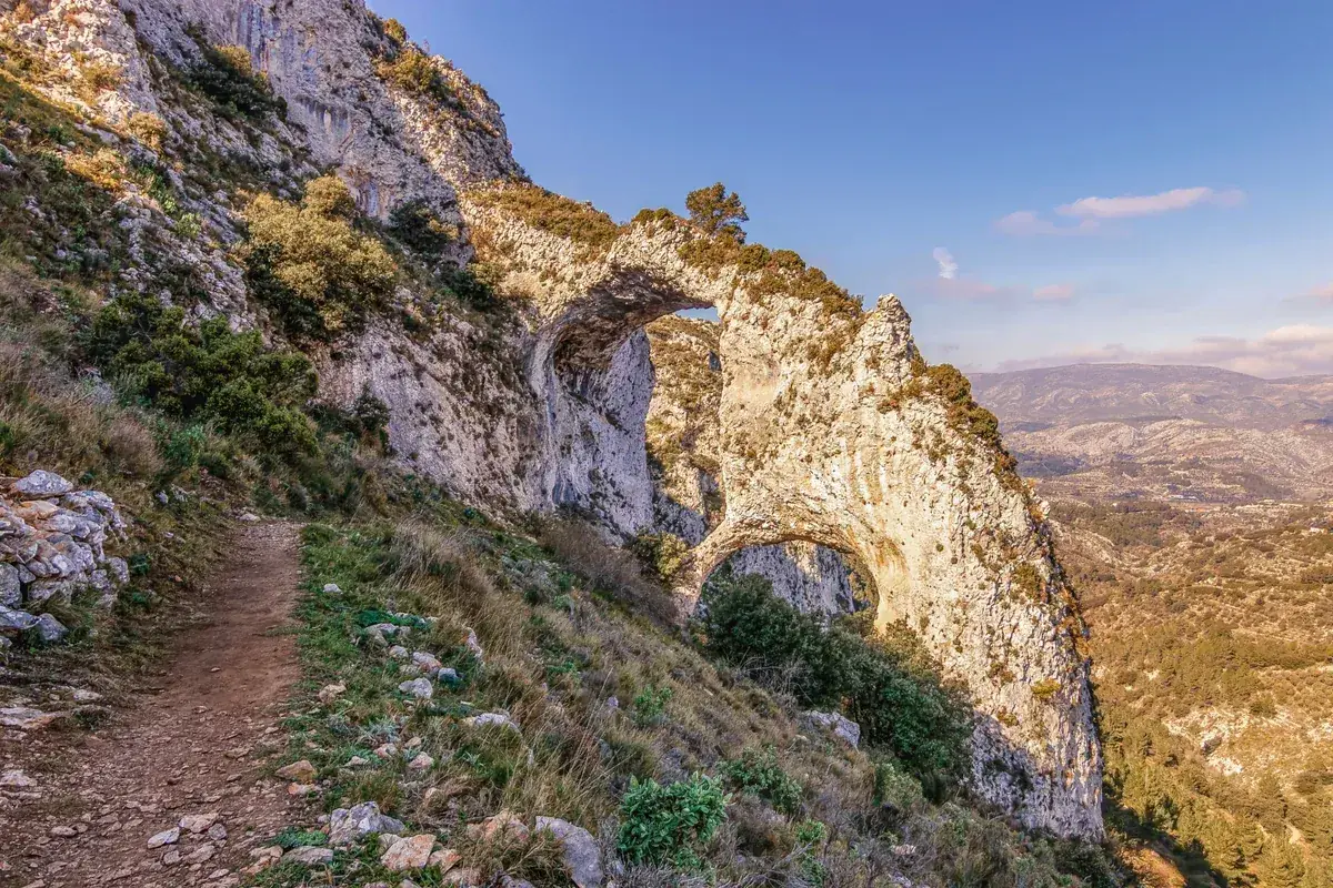 The Els Arcs arches from the trail, the valley opening beyond