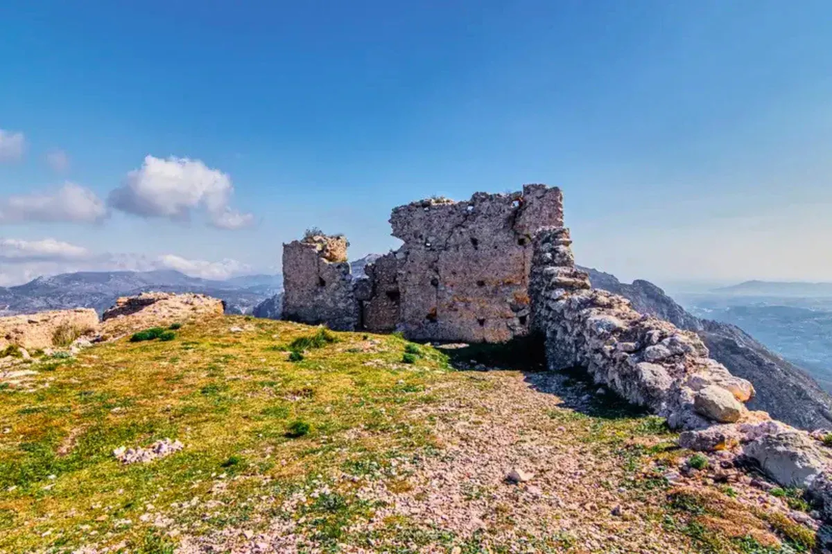 The ruined walls of El Castellet on the summit, the Marina Alta stretching away behind