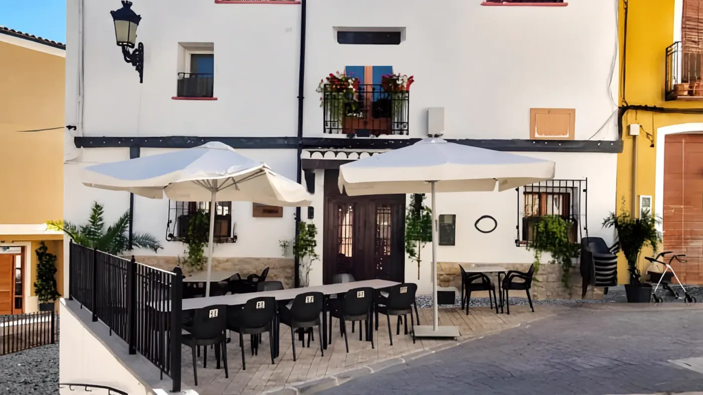 The terrace of Casa Blanca under its parasols, tables waiting on the cobbled square